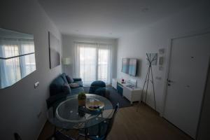 a living room with a blue couch and a glass table at Blanco 35 by SunHousesCanarias in El Tablero