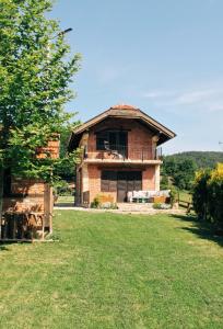 an old brick house in the middle of a field at Una Guest House in Bosanski Novi