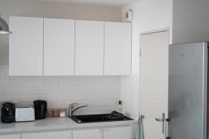 - une cuisine avec des placards blancs et un évier dans l'établissement Splendide appartement 3 pièces - Parking et Clim, à Valence