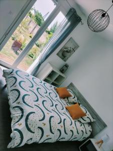 1 dormitorio con 1 cama con almohadas de color naranja y ventana en Gite Le Cherche Midi, en Gaillac