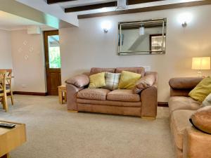 a living room with a couch and a mirror at Bracknell Cottage in Freystrop