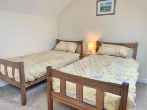a bedroom with two beds and a lamp in it at Bracknell Cottage in Freystrop
