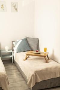 Una cama con una bandeja con una mesa. en Apartament pod lasem, en Ołdrzychowice Kłodzkie