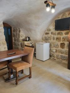a kitchen with a wooden table and a refrigerator at Tarihi ulu cami yanı Tarih çift kişilik oda in Mardin