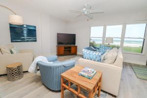 Una sala de estar con un sofá y un televisor. en Sand Dollar 3-106, en St. Augustine