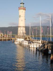 een vuurtoren op een dok met boten in het water bij Appartement an der Ach Lindau in Lindau +2 foto's
