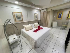 Un dormitorio con una cama con una cinta roja. en Canadá Hotel en Rio Verde