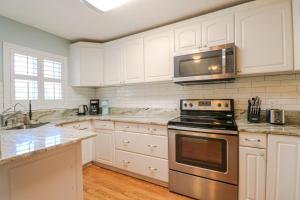 a kitchen with white cabinets and a stove top oven at St Augustine Beach & Tennis Resort 808 in Saint Augustine