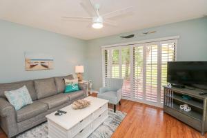 a living room with a couch and a flat screen tv at St Augustine Beach & Tennis Resort 808 in Saint Augustine