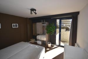 a bedroom with a white bed and a window at DURBUY-COSY APPARTEMENT in Durbuy
