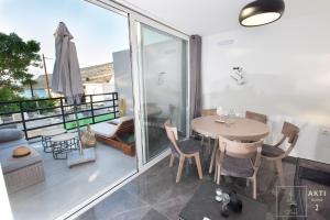 een kamer met een balkon met een tafel en stoelen bij AKTI Homes Matala in Matala