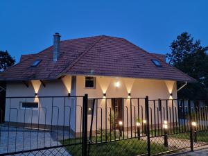una casa con una valla delante de ella en Forest House Balaton, en Cserszegtomaj