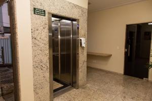 Un ascensor en un edificio con un cartel en la pared. en Canadá Hotel, en Rio Verde