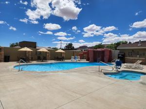 a pool at a resort with chairs and umbrellas at Comfort Suites Kanab National Park Area in Kanab