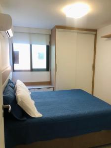 - une chambre avec un lit bleu et une fenêtre dans l'établissement Apto paraíso praia dos anjos, à Arraial do Cabo