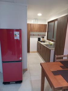 a kitchen with a red refrigerator and a table at Casa Interior en La Cruz Quillota in Quillota