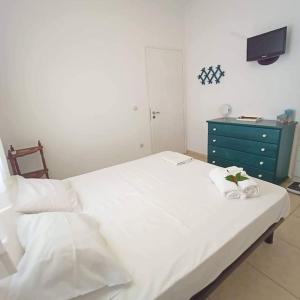 a bedroom with a white bed and a blue dresser at paros seaside experience in Aliki