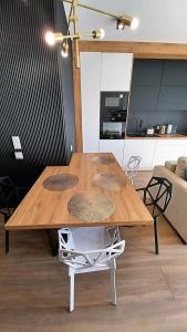 drewniany stół w salonie z kuchnią w obiekcie Kima Apartament Bażantów 44 w mieście Katowice