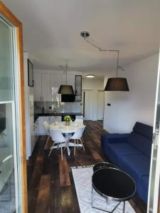 un soggiorno con divano blu e tavolo di Apartamenty Mazurska Bryza nad Iławką a Iława
