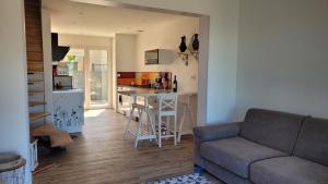 a living room with a couch and a kitchen at Gîte Du Soleil Maison lumineuse avec terrasse solarium parking privé in Sorède