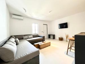 un soggiorno con un divano e un tavolo di Ananke with Shared Pool a Mykonos Città