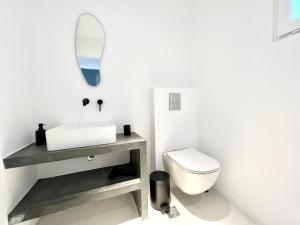 un bagno bianco con lavandino e WC di Ananke with Shared Pool a Mykonos Città 1 altra foto