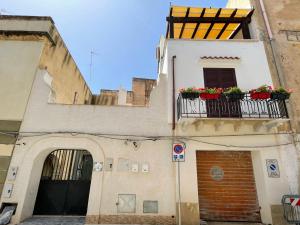 a building with a balcony with flowers on it at Grazia Vecchia 38 in Marsala