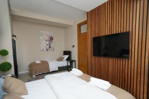 a room with two beds and a flat screen tv at Sweet69apartments JP in Niš