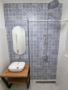 uma casa de banho com um lavatório e um chuveiro com um espelho. em Apartmani Maja em Tučepi