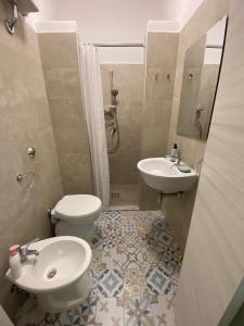 y baño con aseo y lavamanos. en B&B Maria Montis, en Assemini