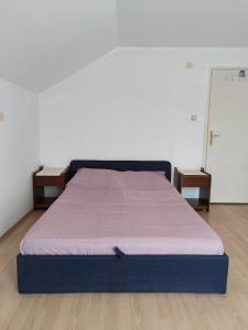 a bed in a room with two night stands at House of the Rising Sun in Bosanska Gradiška