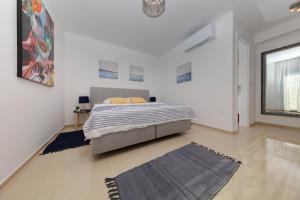 a white bedroom with a bed and a rug at Resort Banjole - apartman Indigo in Banjole +57 photos