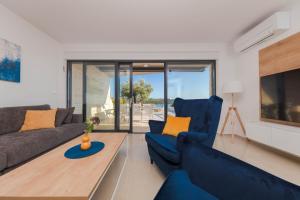 a living room with blue couches and a tv at Resort Banjole - apartman Indigo in Banjole