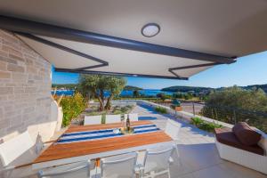 a patio with a table and chairs and a view of the ocean at Resort Banjole - apartman Indigo in Banjole