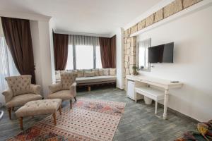 a living room with a couch and a table and chairs at Albeon Luxury Hotel - Alacatı in Alaçatı