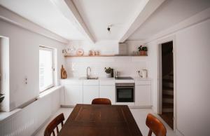 uma cozinha com mesa e cadeiras e uma janela em Altes Töpferhaus em Husum