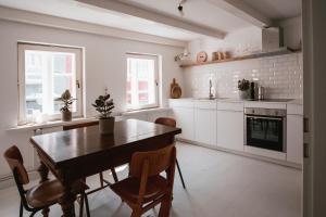 a white kitchen with a wooden table and chairs at Altes Töpferhaus in Husum