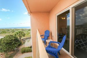 - deux chaises bleues sur un balcon avec vue sur l'océan dans l'établissement Creston House 1E, à Saint Augustine
