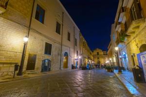 una strada vuota di notte in un centro storico di Antica Dimora Luxury Rooms a Barletta