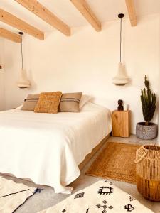 a bedroom with a white bed and a cactus at Can Yuca II in Cala Mondrago