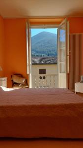 a bedroom with a large bed and a large window at La casa del Mago camere e appartamenti in Pissignano