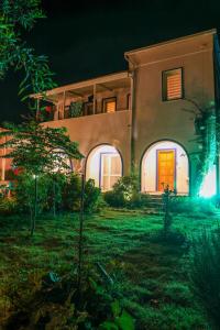 una casa con una puerta naranja en un patio por la noche en Yalıyanı Pansiyon en Yaliciftlik