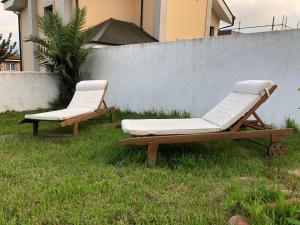 two lounge chairs sitting in the grass next to a fence at La Casita de El Montán in Avilés +7 photos