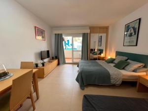 1 dormitorio con cama, mesa y escritorio en BENALBEACH LOFT Encatador en Benalmádena