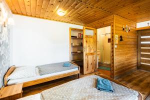 a bedroom with two beds in a wooden cabin at uKozaków in Zubrzyca Dolna