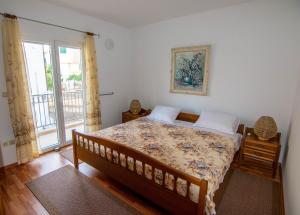 - une chambre avec un lit et une grande fenêtre dans l'établissement Apartments Bonis Šibenik, à Šibenik
