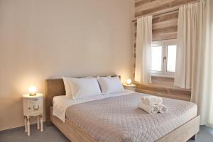 a bedroom with a bed with two towels on it at Porfyra Suite & Spa 1 in Skala
