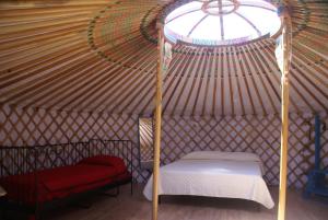 a room with a bed and a chair in a yurt at Yurta Gaia in Torino di Sangro