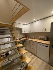 a kitchen with white cabinets and a staircase in it at Apartament Pod 12 B in Bielsko-Biała