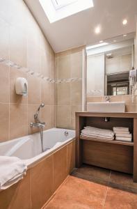 La salle de bains est pourvue d'une baignoire et d'un lavabo. dans l'établissement Residence Les Chataigniers, à Saint-Jorioz